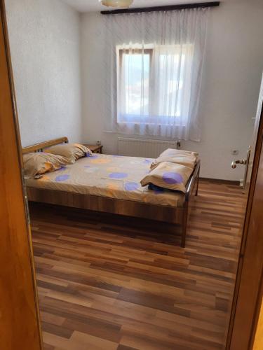 a bedroom with a bed and a window at Vreshtat e Liqenit-Ezerski Llozja in Struga
