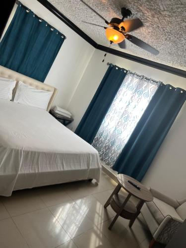 1 dormitorio con 1 cama y 1 silla junto a una ventana en R & A turquoise Rental en Providenciales