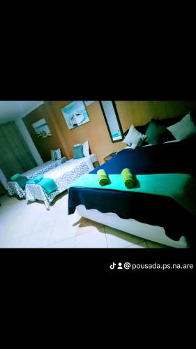 2 Betten in einem Schlafzimmer mit blauer Bettwäsche in der Unterkunft Pousada pés na areia in Serra