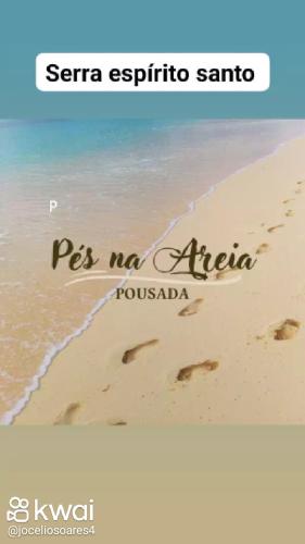una foto de una playa con huellas en la arena en Pousada pés na areia en Serra