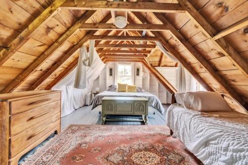 1 dormitorio con cama y mesa en el ático en Quaint Maine Coast Cottage, en Saint George