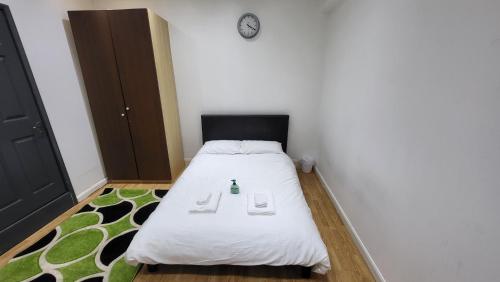 Dormitorio pequeño con cama con cabecero negro en Oleon en-suite Rooms - Ilford, London, en Ilford