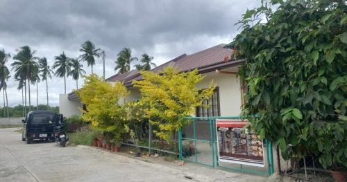 a truck parked next to a house with palm trees at Radex Place Staycation , 2BR, 6 PAX in Mati