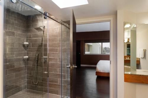 W łazience znajduje się prysznic ze szklanymi drzwiami. w obiekcie Walnut Creek Marriott w mieście Walnut Creek
