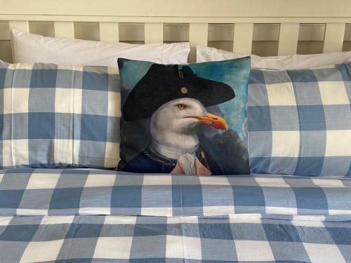 a painting of a bird wearing a pirate hat on a bed at Mission Retreat in Kerikeri