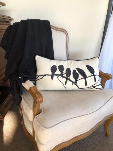 a pillow with birds on a branch on a chair at Wake Up to Stunning Views - Luxury Counrty Escape by Scotch Hill Truffle Farm in Neerim South