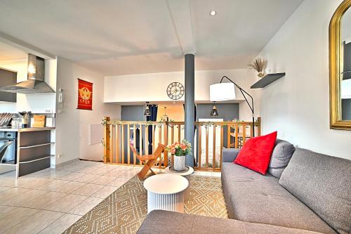 a living room with a gray couch and a red pillow at Triomphe - Vue Sublime, Confort Moderne, Charme Gallo-Romain, Cœur de Ville, Tv 4K, Fibre in Saintes