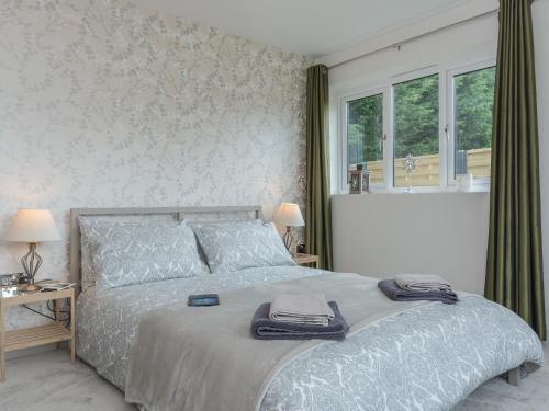 a bedroom with a bed with two towels on it at Lavender Lea in Henley in Arden