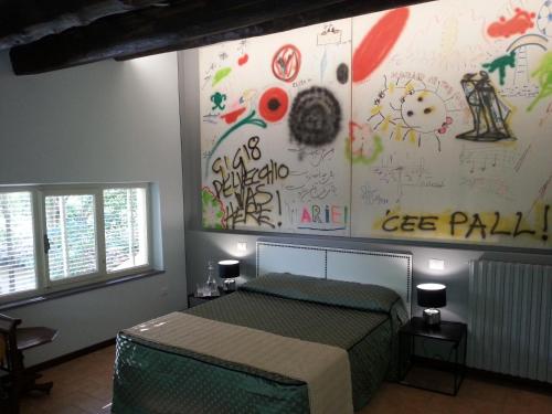 カンペッロ・スル・クリトゥンノにあるPieve Sant'Angeloのベッドルーム1室(壁に落書きが施されたベッド1台付)