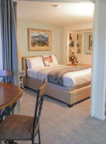 um quarto com uma cama e uma mesa e uma mesa e cadeiras em The Landmark Inn on Orcas Island em Eastsound