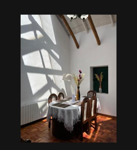 a dining room with a table and chairs and a shadow at Contando Historia in Potosí