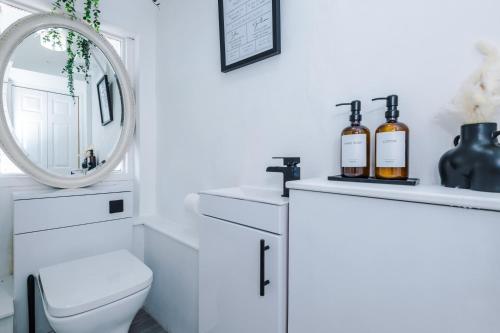 Stunning 3 br house near Leeds City Centre with Free Parking في Hunslet: حمام ابيض مع مرحاض ومرآة