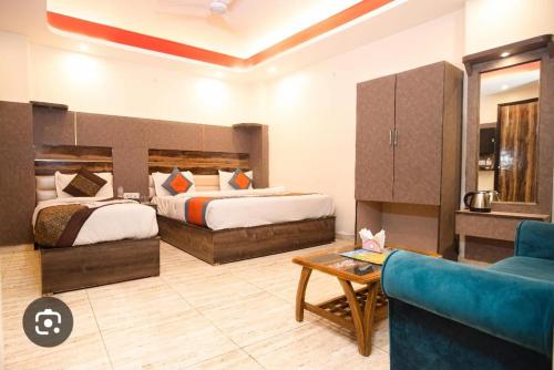 a hotel room with two beds and a couch at THE RED DIAMOND NEAR IGI AIRPORT new DELHI in New Delhi