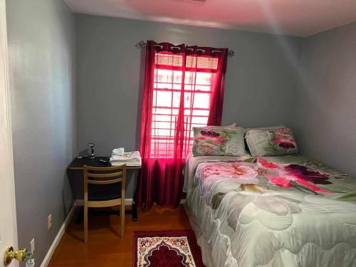 a bedroom with a bed and a desk and a window at Room F Divine Villa and Resorts 5mins to EWR Airport and 4mins to Penn Station Newark, 20Mins to New York in Newark