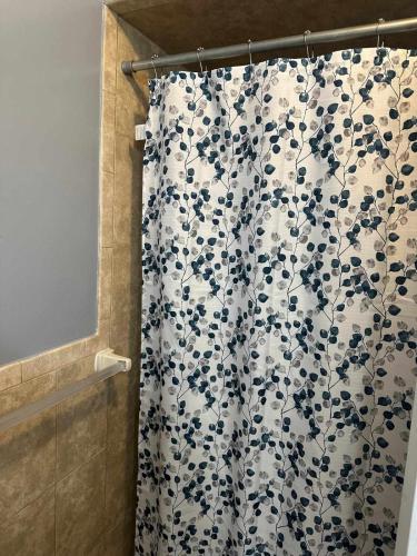a bathroom shower with a blue and white shower curtain at Divine Villa and Resorts 67 Sherman 5mins to EWR Airport and 4mins to Penn Station Newark, 20Mins to New York in Newark