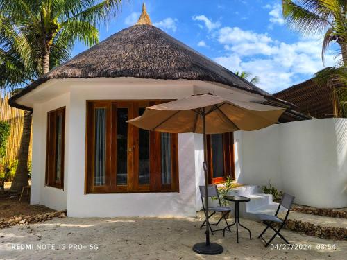 a small house with a table and an umbrella at U Story Resort in Siquijor