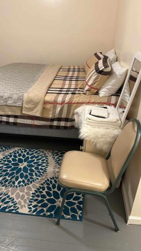 a bedroom with a chair next to a bed at Room J Divine Villa and Resorts 5mins to EWR Airport and 4mins to Penn Station Newark, New York in Newark