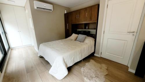 una camera da letto con un letto e un piumone bianco di Hermoso apartamento con terraza! Punta Carretas a Montevideo