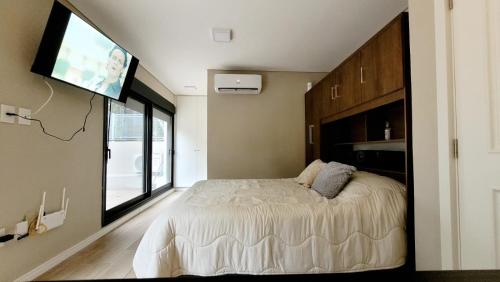 Schlafzimmer mit einem Bett und einem Flachbild-TV in der Unterkunft Hermoso apartamento con terraza! Punta Carretas in Montevideo