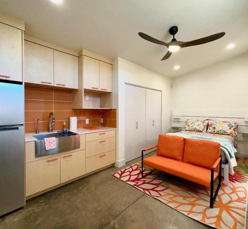 - une cuisine avec une chaise orange et un lit dans l'établissement Tiny House Centrally Located in Great Neighborhood, à Phoenix
