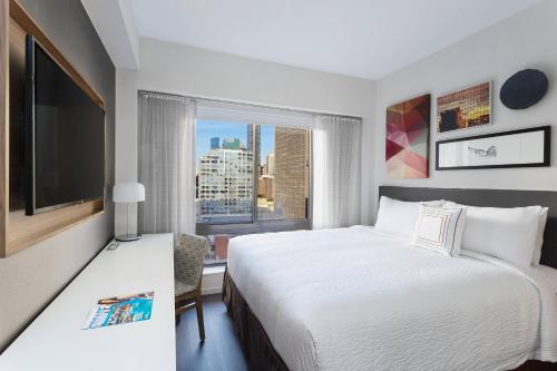 a hotel room with a bed and a large window at Fairfield Inn & Suites by Marriott New York Manhattan/Central Park in New York