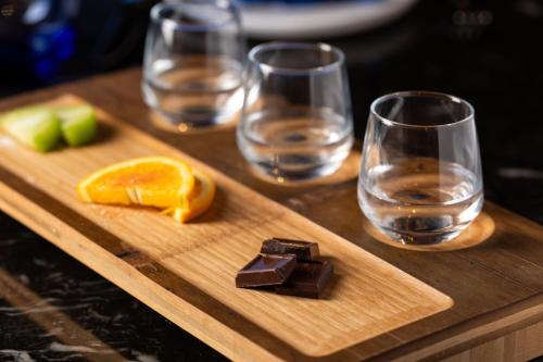 a wooden cutting board with glasses of water and chocolate at The Drake Oak Brook, Autograph Collection in Oak Brook