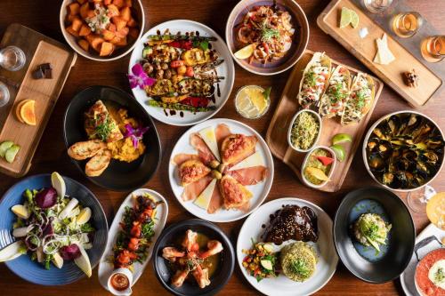 a table with many plates of food on it at The Drake Oak Brook, Autograph Collection in Oak Brook
