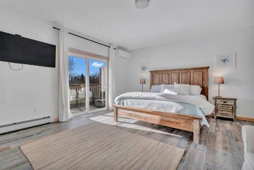 een slaapkamer met een groot bed en een groot raam bij Ocean View East Duplex with Walk to Crescent Beach in Owls Head