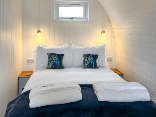 a bedroom with a bed with two towels on it at Bombie Glamping Pod in Cromdale