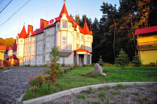 un grand bâtiment avec des toits rouges dans une cour dans l'établissement Oazis-M, à Babin