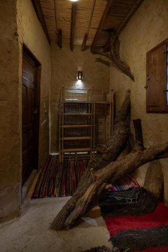 a room with a large tree branch on the floor at Olive Garden House Siwa in Siwa