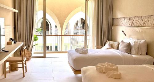 ein Hotelzimmer mit 2 Betten und einem großen Fenster in der Unterkunft Navakiri Boutique Resort Satun 
