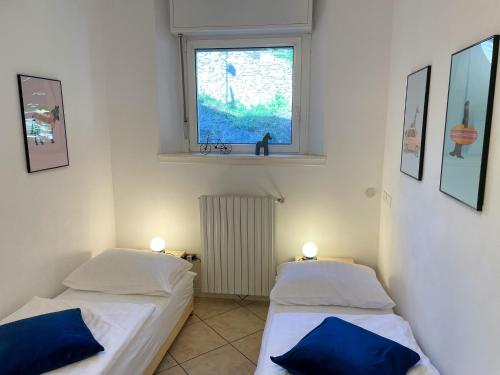 twee bedden in een kamer met een raam bij Paradiso Panoramico in Sueglio
