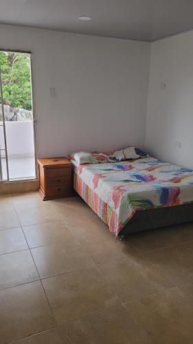 Schlafzimmer mit einem Bett und einem Fenster in der Unterkunft Casa Villaconcha in Valledupar