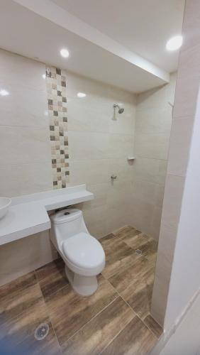 a bathroom with a white toilet and a sink at Casa Villaconcha in Valledupar