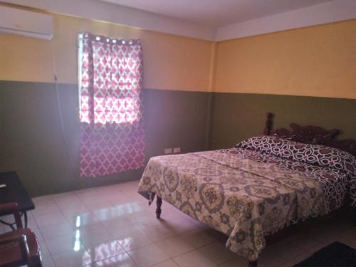 a bedroom with a bed and a window at Theo Alluring Maison in Balata