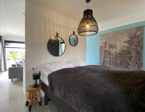 ein Schlafzimmer mit einem Bett und zwei Spiegeln an der Wand in der Unterkunft Marina Strandbad Wellness-Chalet Romantik Haus Nr 411 in Olburgen