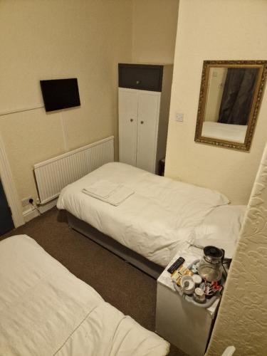 a hotel room with two beds and a mirror at Winston House in Bridlington