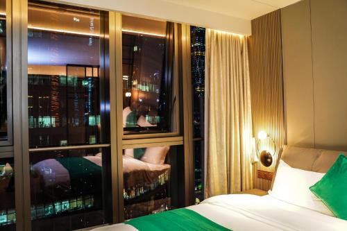 a room with a bed and a window with a view at BaiYue Apartment - Zhujiang New City Guangzhou in Guangzhou