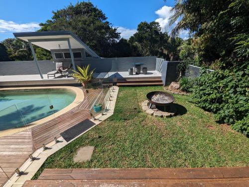 un patio trasero con piscina y fogata en Luxury oasis resort Pet friendly apartment with private pool and spa en Port Macquarie