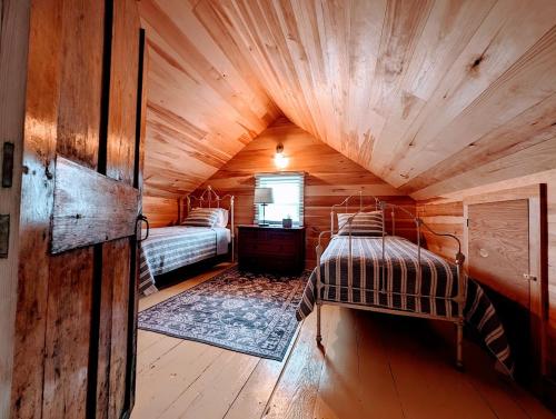 Habitación con 2 camas en una cabaña de madera en Oceanside Saltwater Cottage NEW, en Milbridge