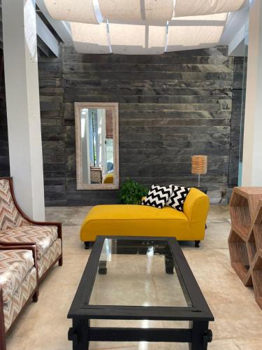 a living room with a yellow couch and a table at New Kuta Suites in Jimbaran
