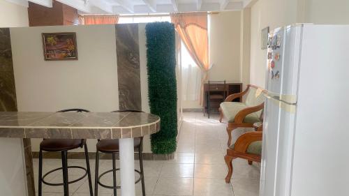 a kitchen with a counter and a green wall at SUITE AMOBLADA TODO INCLUIDO in Quito