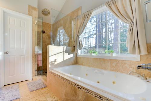 ein großes Bad mit einer Badewanne und einem Fenster in der Unterkunft Top Choice Family Vacation House Walkable to Shops in Cary