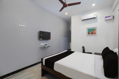 um quarto com uma cama e uma televisão de ecrã plano em OYO ARN RESIDENCY em Chennai