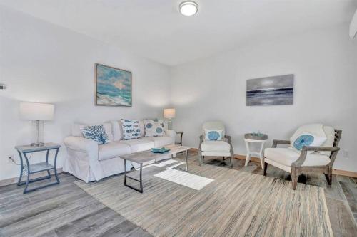 uma sala de estar com um sofá e duas cadeiras em Ocean View West Duplex with Walk to Crescent Beach em Owls Head