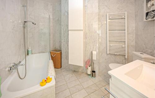 een badkamer met een bad, een toilet en een wastafel bij Lovely Apartment In Oostende With Kitchen in Oostende