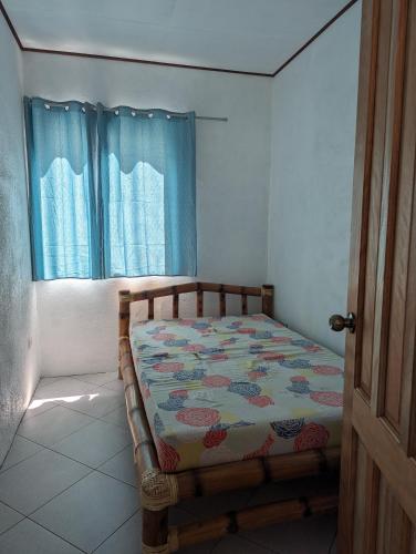 a bed sitting in a room with a window at Green House Boracay in Boracay