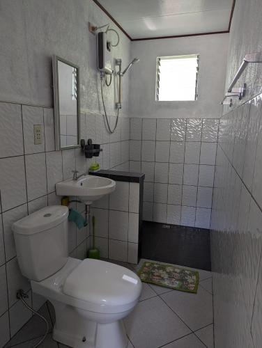a bathroom with a white toilet and a sink at Green House Boracay in Boracay
