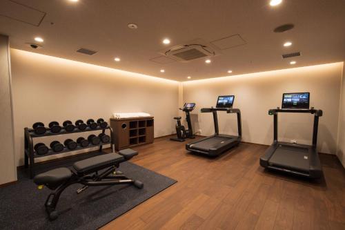 a gym with two treadmills and exercise equipment in a room at Hotel Okura Kyoto Okazaki Bettei in Kyoto